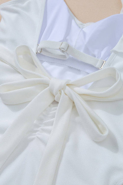 Close-up of bow detail on white swimwear