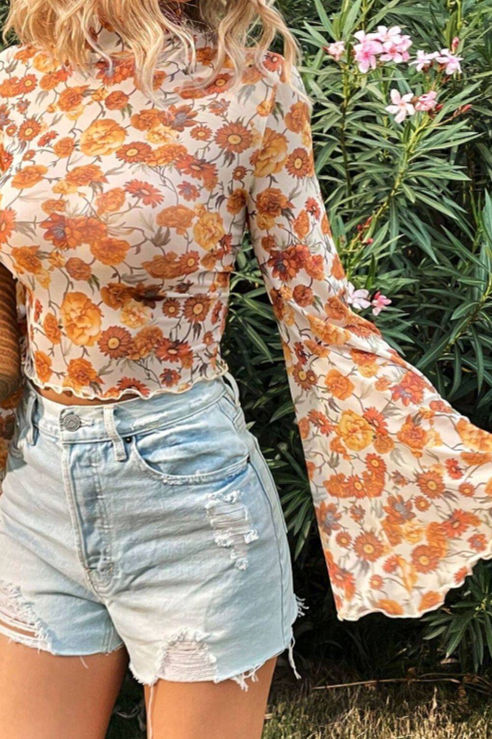 Close-up of floral flare sleeve top with denim shorts