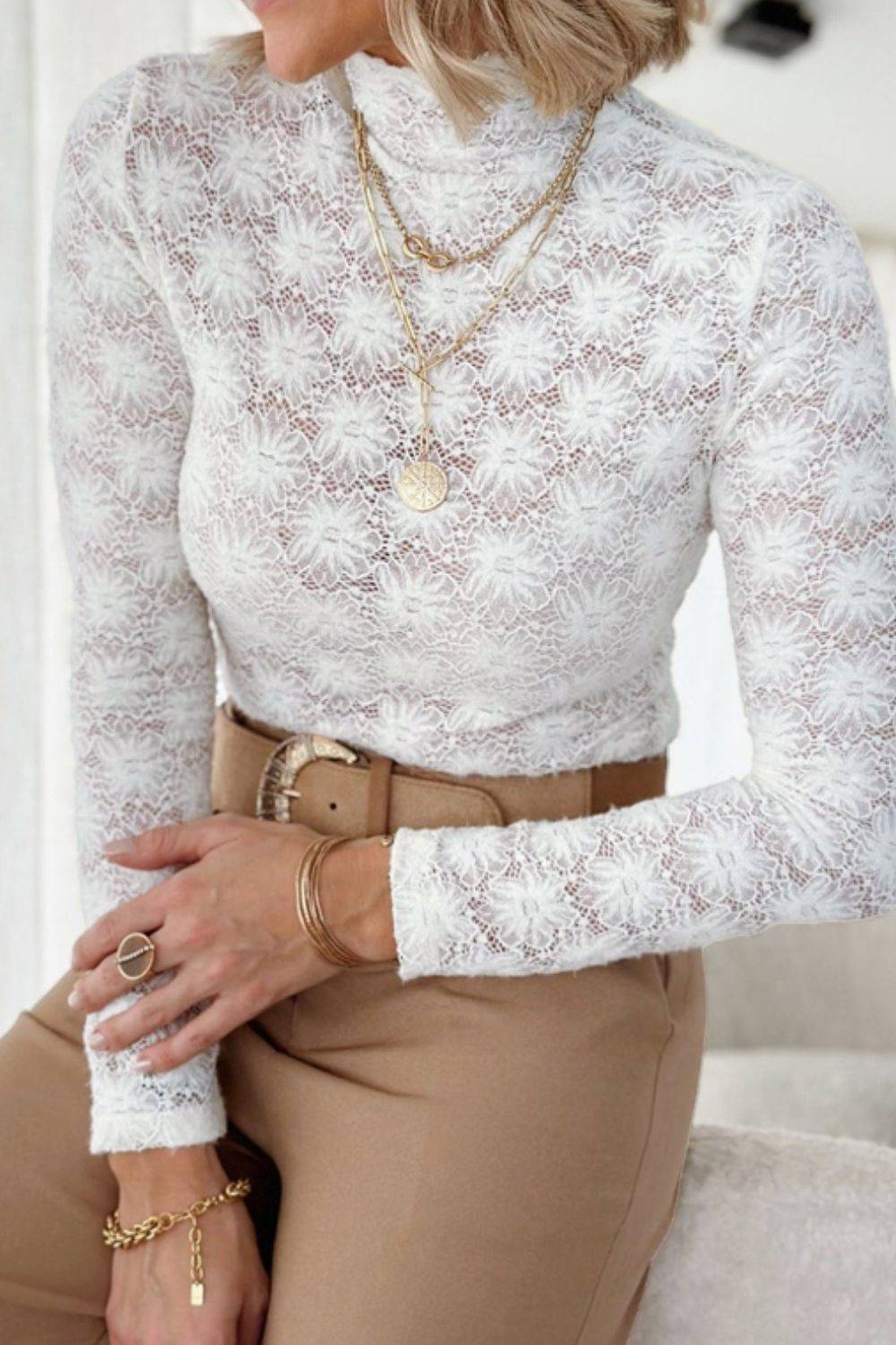 White mock neck lace top with long sleeves, styled with jewelry.