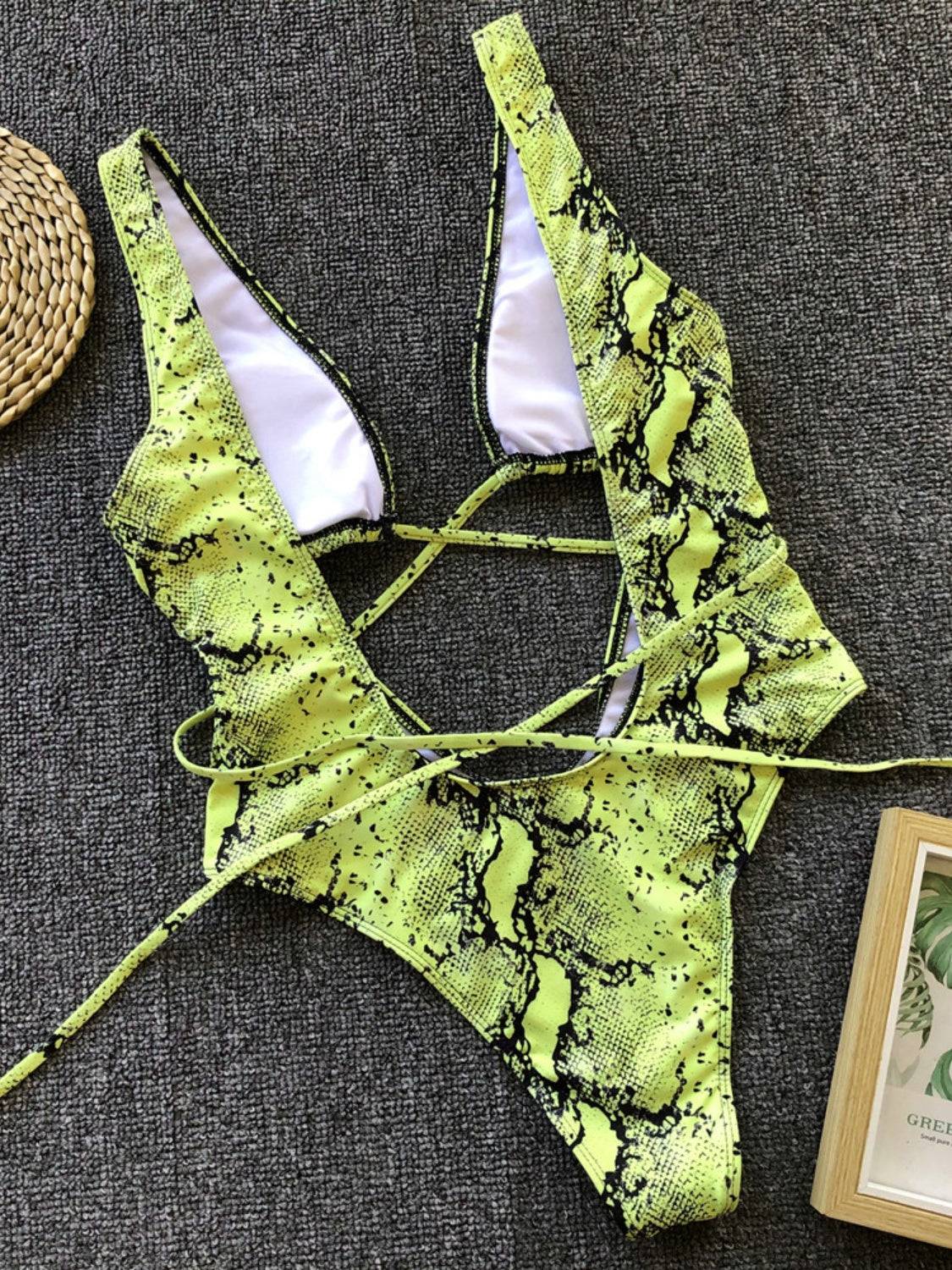 Flat lay of green snake print lace-up swimwear