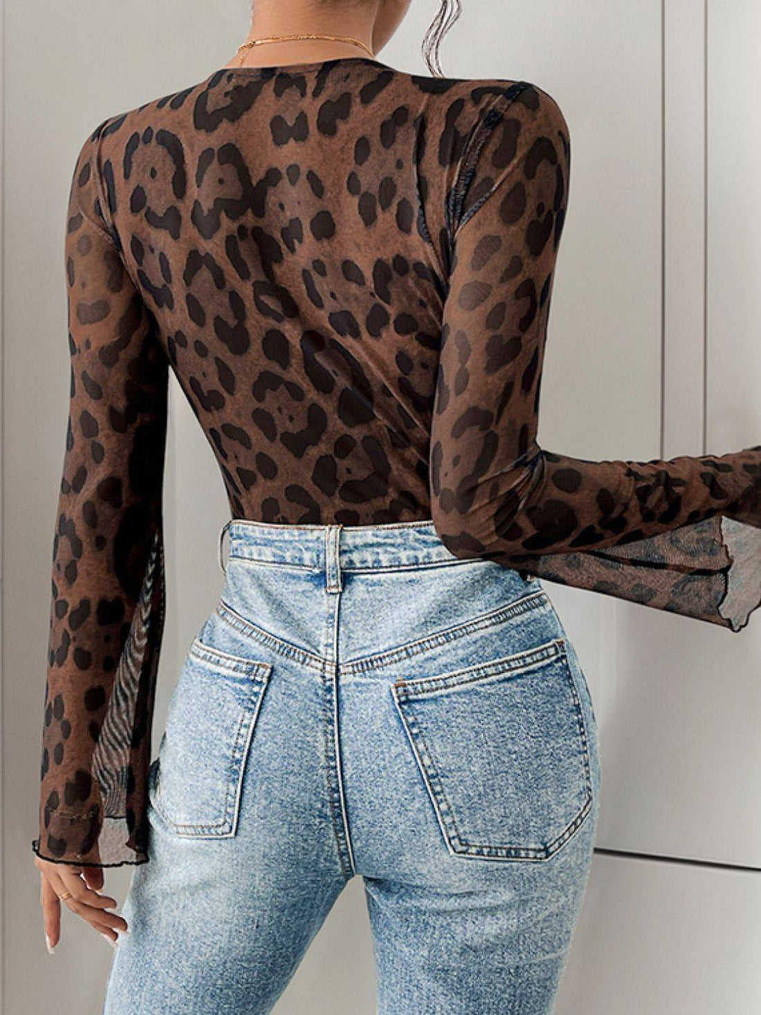 Back view of leopard lace bodysuit with denim jeans