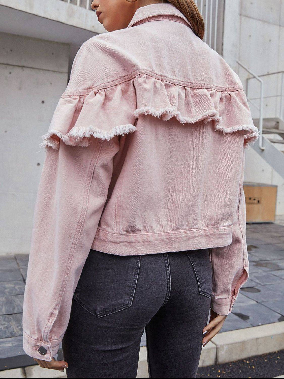 Back view of pink denim jacket with ruffled detail