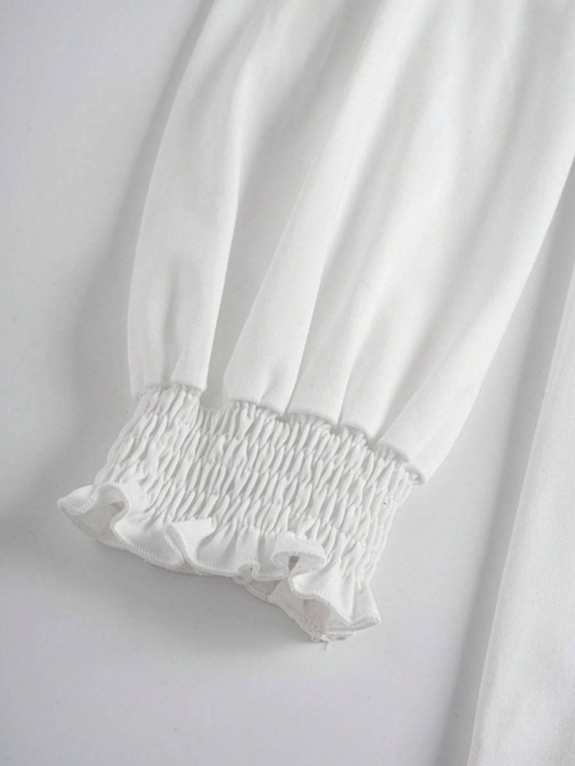 Close-up of smocked cuff on white long sleeve t-shirt