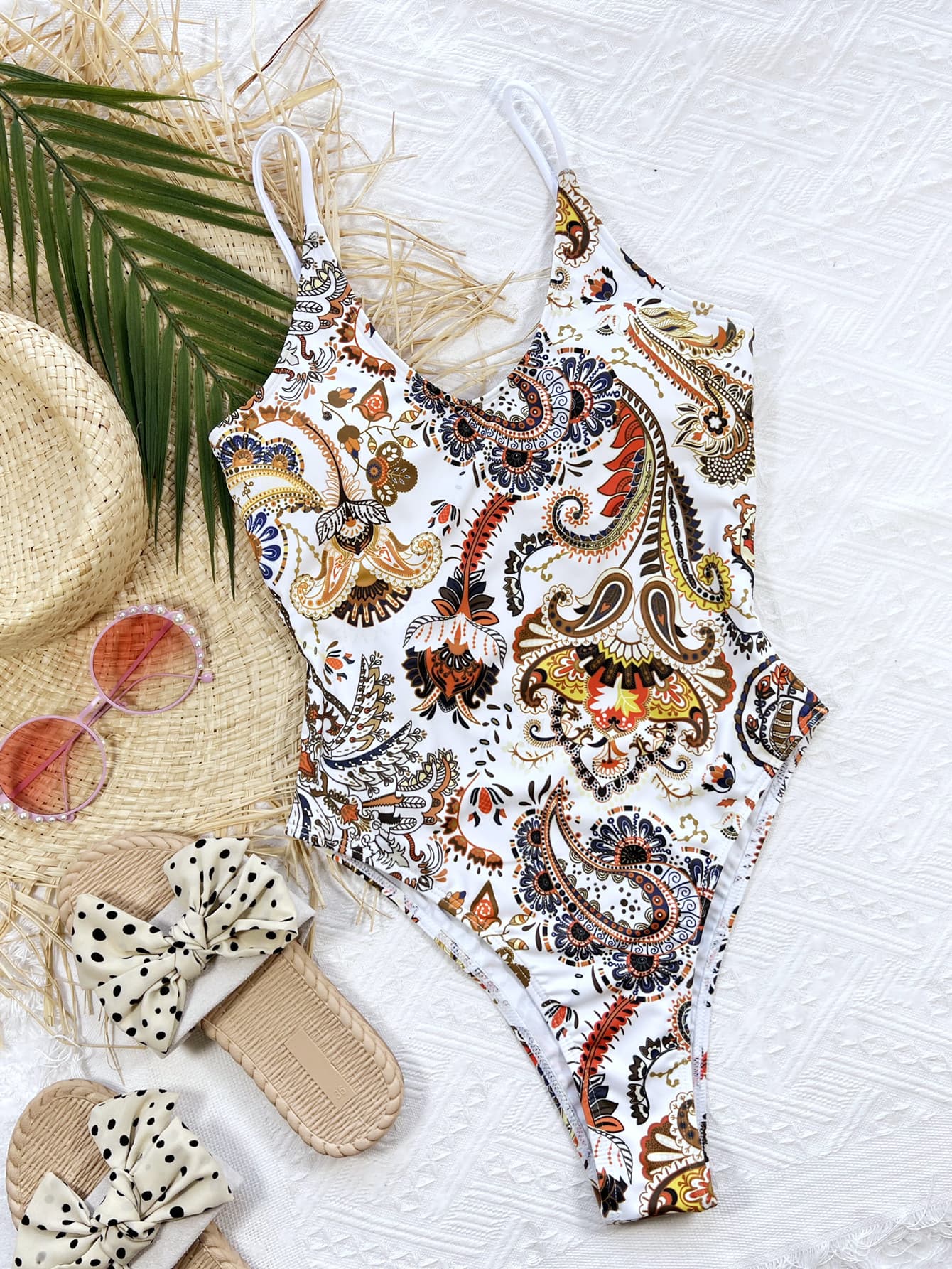 Printed one-piece swimsuit with accessories flat lay