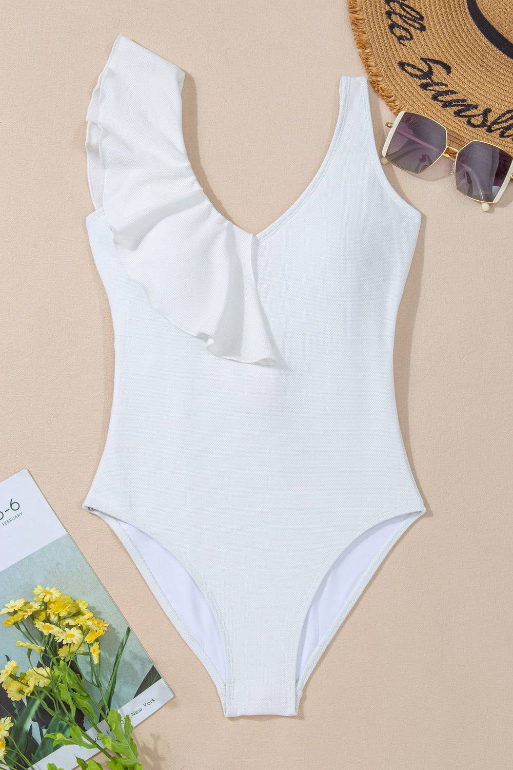 Flat lay of white ruffled V-neck swimwear