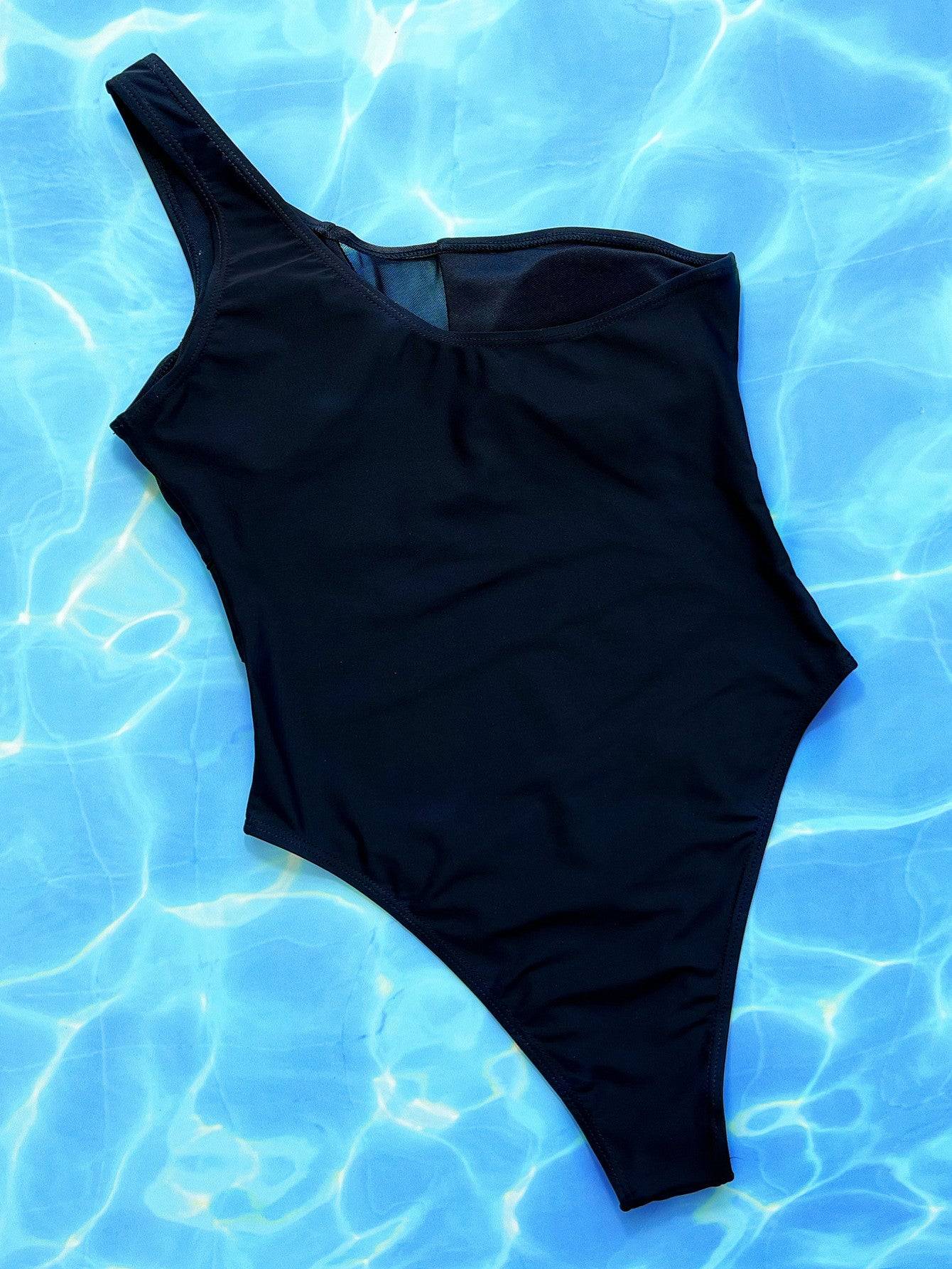 Black one-shoulder swimsuit on blue water background.