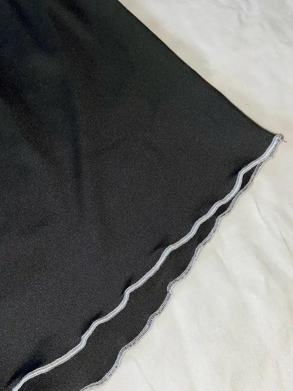 Close-up of black pajama shorts with scalloped hem