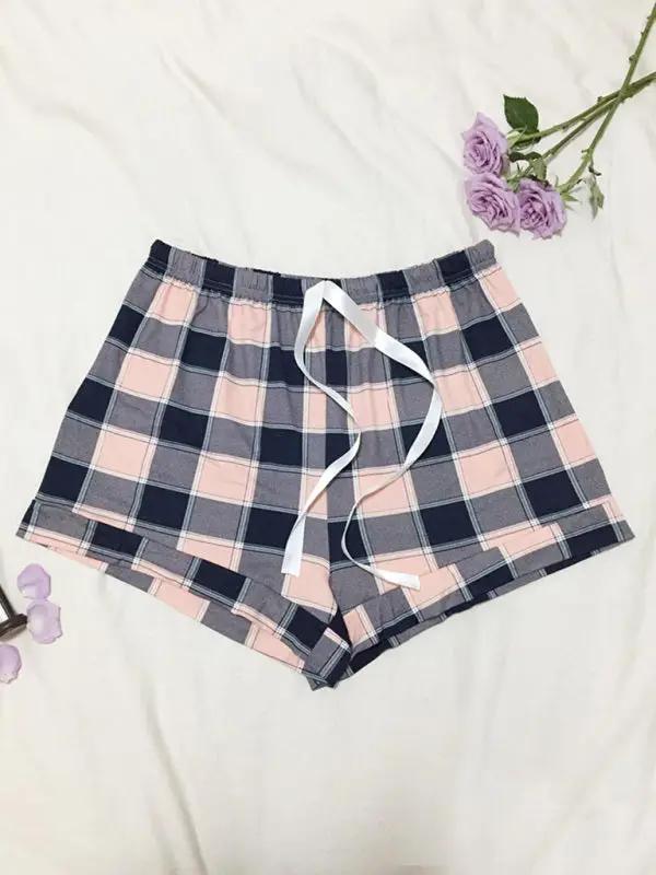 Plaid pajama shorts with white ribbon and purple flowers.