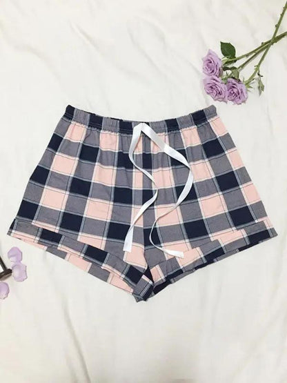 Plaid pajama shorts with white ribbon and purple flowers.