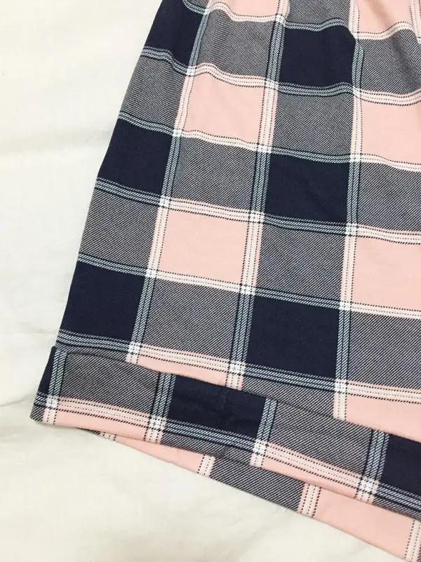 Close-up of plaid pattern on knitted pajama shorts.