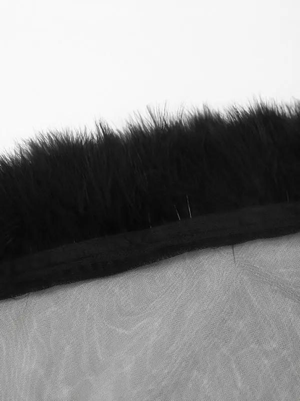Close-up of black feather detail on mesh fabric