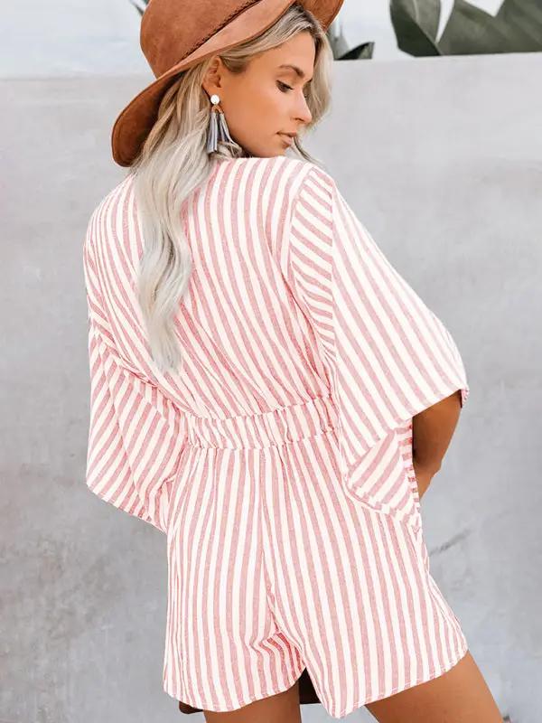 Back view of pink striped jumpsuit with trumpet sleeves
