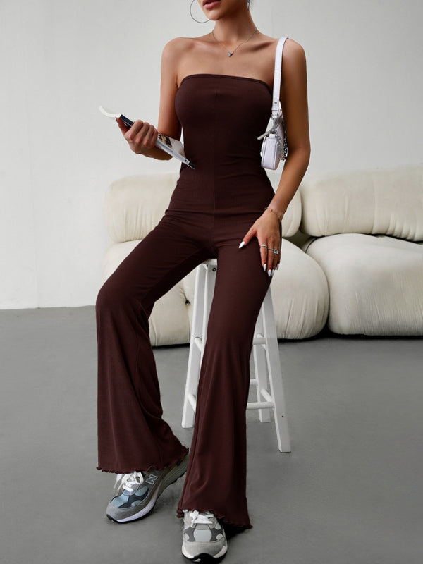 Brown jumpsuit, seated with magazine, chic style