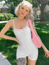 Woman in slim fit white backless suspender jumpsuit outdoors