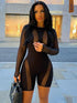 Woman in black mesh see-through slim fit jumpsuit outdoors