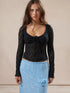 Model in black lace shirt and blue skirt