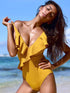 Model posing in yellow ruffled one-piece swimsuit