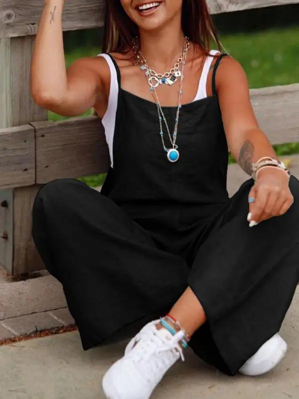 Black suspender jumpsuit with wide leg pants, seated view