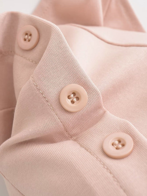 Close-up of pink multi-button detail on skirt