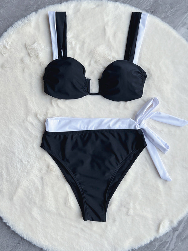 Black bikini set with white trim and bow, laid flat