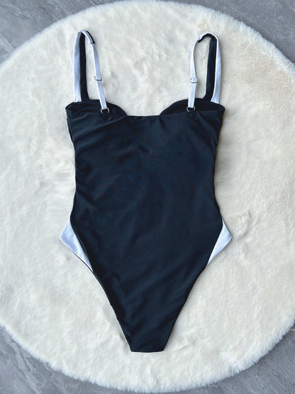 Flat lay of deep V contrast color one-piece swimsuit on fur rug