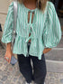 Close-up of striped blouse with silver bag
