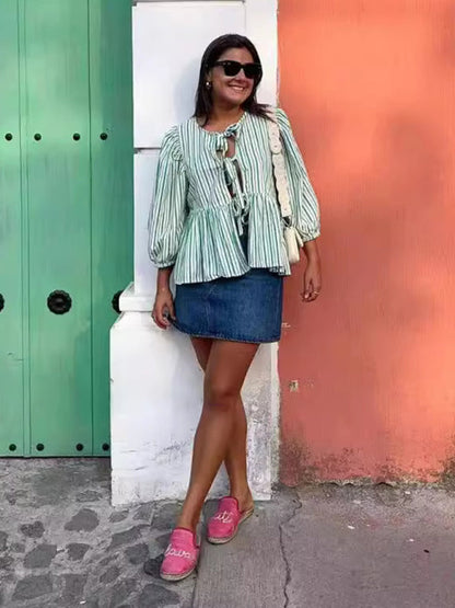 Woman in striped blouse and denim skirt outdoors