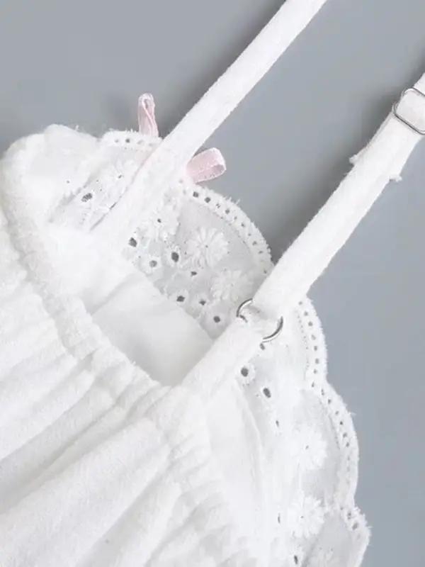Close-up of lace detailing on white suspenders dress