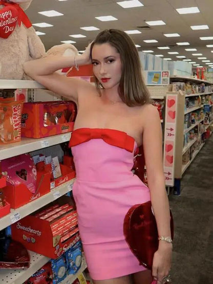 Model in pink tube top dress with red bow in store