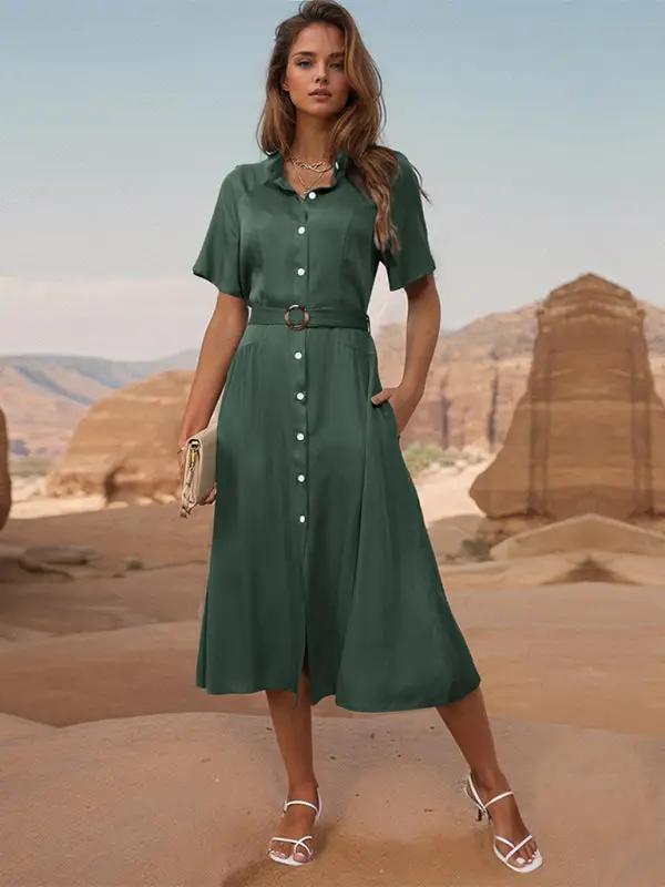 Model wearing green lapel single breasted dress in desert.