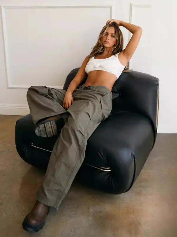 White camisole with loose khaki pants on black chair