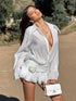 White ruffled V-neck shirt dress in outdoor setting