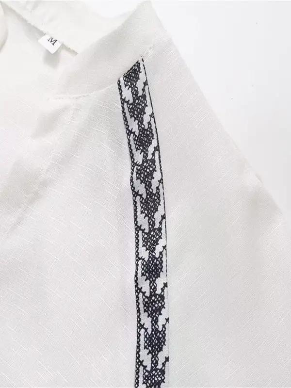 Close-up of cross-stitch detail on white shirt