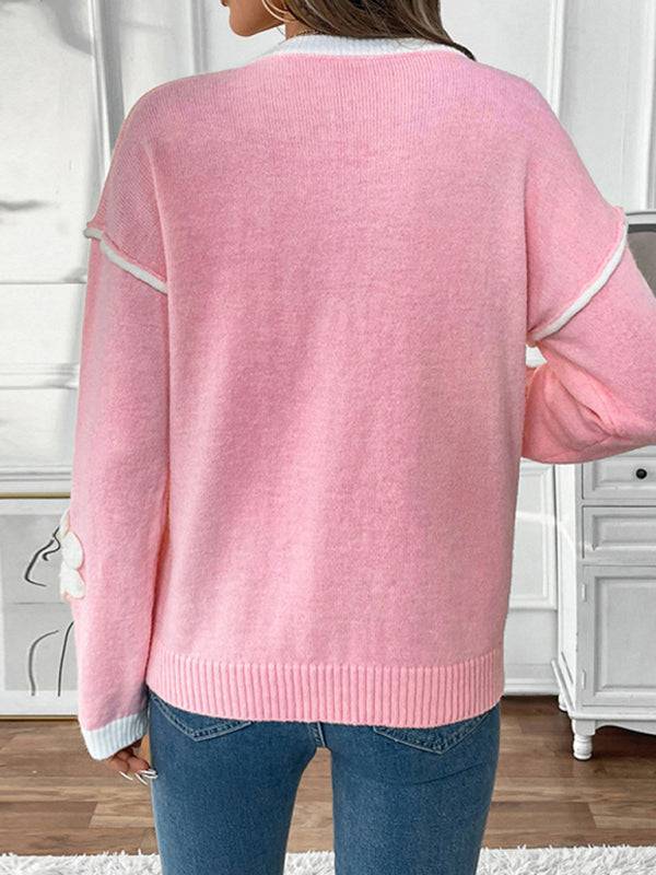 Back view of pink sweater with white trim and floral design