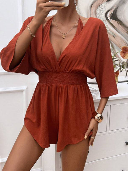 Halter neck rust jumpsuit with a flattering cinched waist