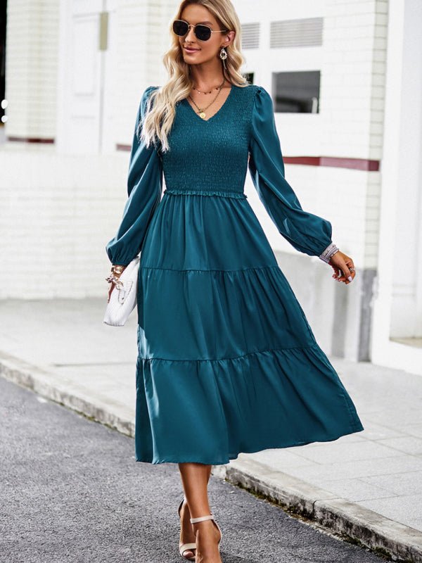 a woman in a teal dress is walking down the street