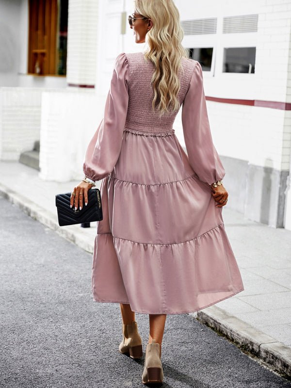 a woman in a pink dress is walking down the street