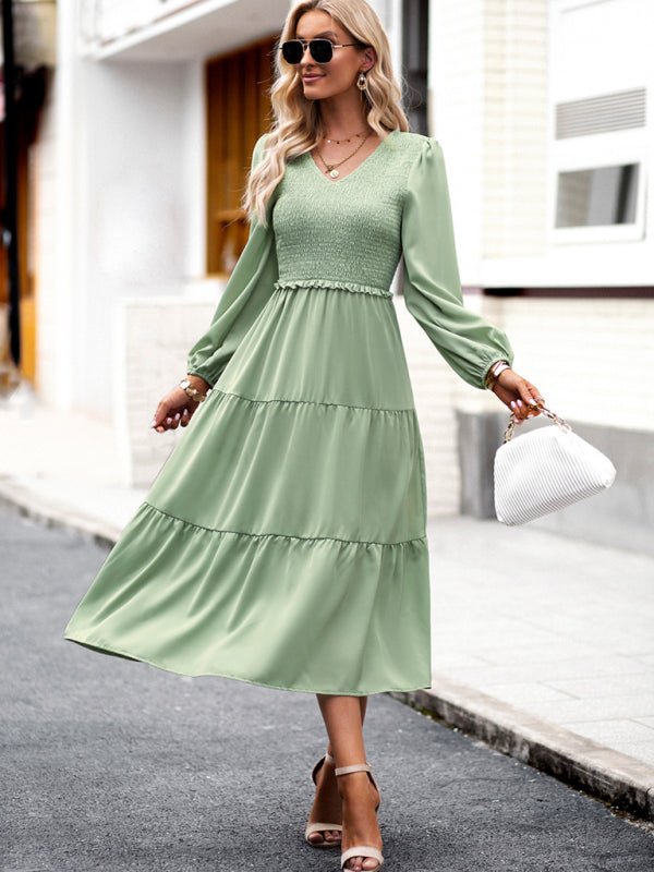 a woman in a green dress is walking down the street