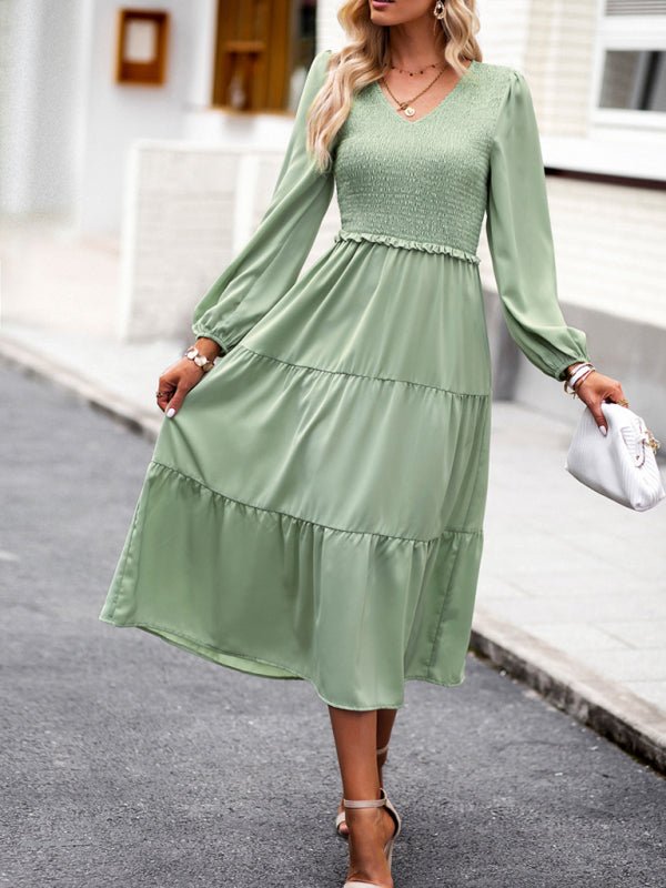 a woman in a green dress is walking down the street