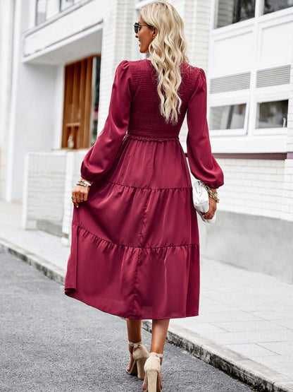 a woman in a red dress is walking down the street