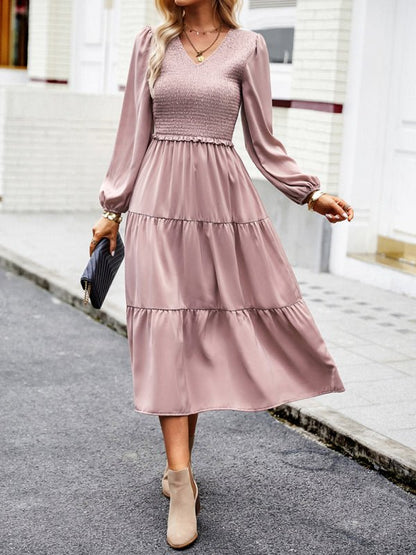 a woman in a pink dress is walking down the street