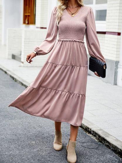 a woman in a pink dress is walking down the street