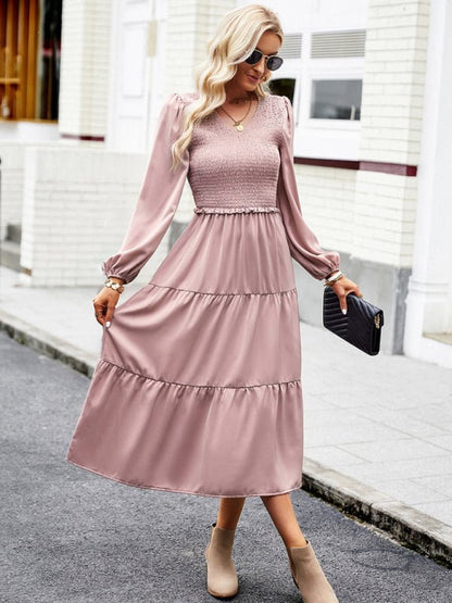 a woman in a pink dress is walking down the street