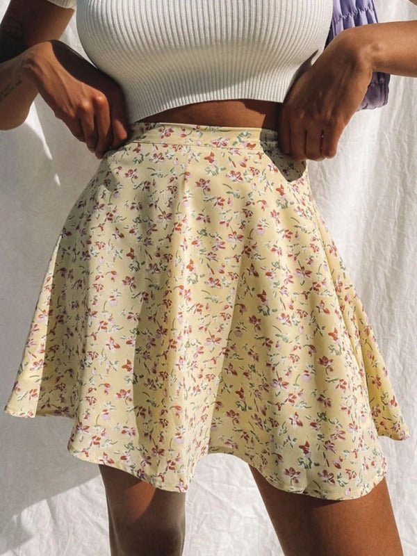 a woman wearing a white top and a floral skirt