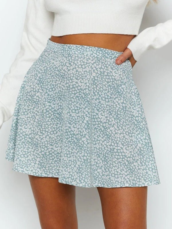 a woman in a white sweater and blue floral print skirt