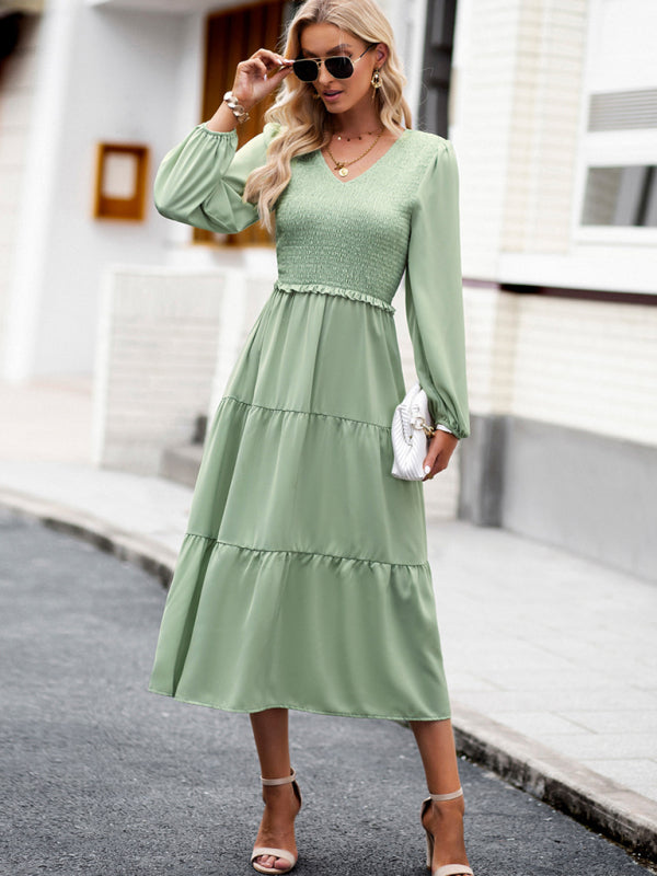 a woman in a green dress is standing on the street