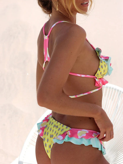 a woman in a bikini standing next to a white chair