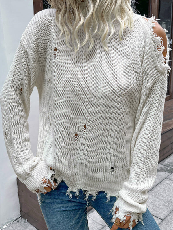 a woman wearing ripped jeans and a white sweater