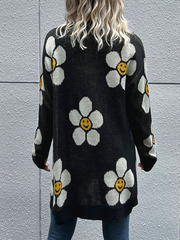 a woman wearing a black sweater with white flowers on it