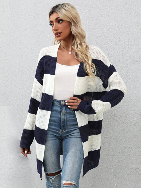 a woman wearing a striped cardigan sweater and ripped jeans